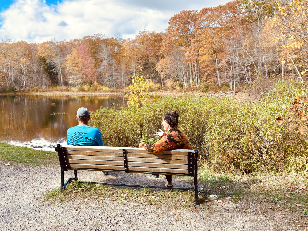 Therapy session outside on a parkbench by a pond